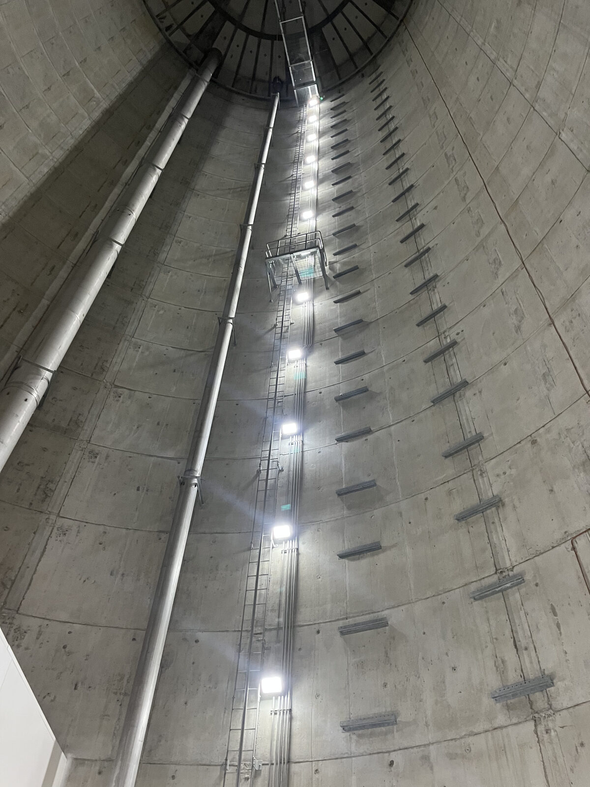 Interior of a concrete water tower with ladder, conduit risers and LED lighting installed by Max Electric